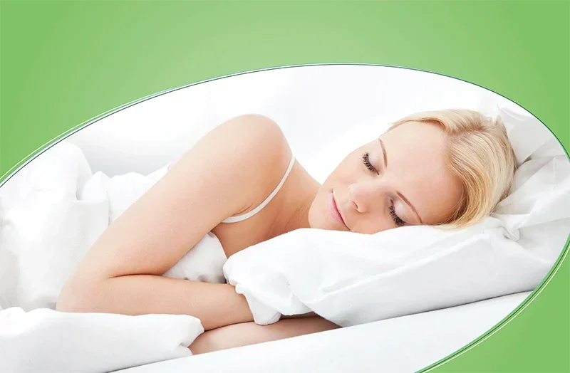 Woman peacefully sleeping with head on a soft white cuddle-friendly pillow in a cozy bed