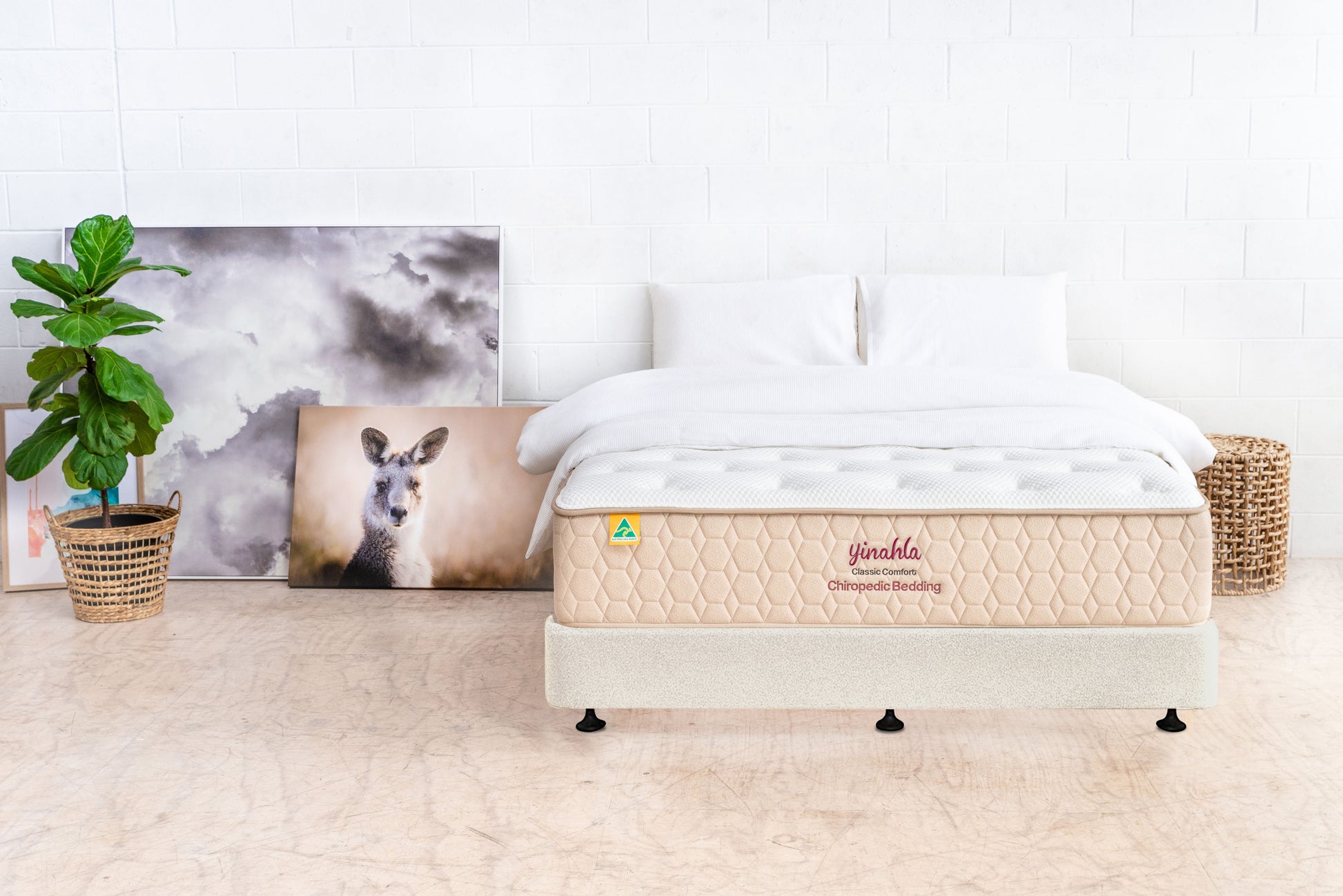 Classic Comfort orthopedic mattress with white bedding in minimalist room with plant and kangaroo art