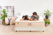 Couple lying on yinahla Classic Comfort orthopedic mattress in bright room with plants and kangaroo photo
