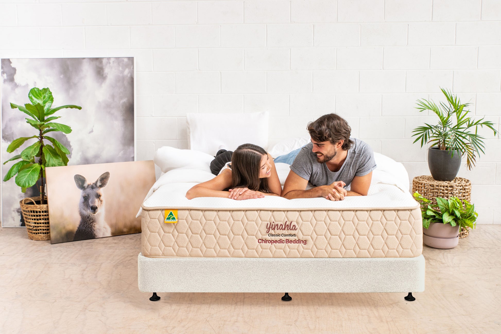 Couple lying on yinahla Classic Comfort orthopedic mattress in bright room with plants and kangaroo photo