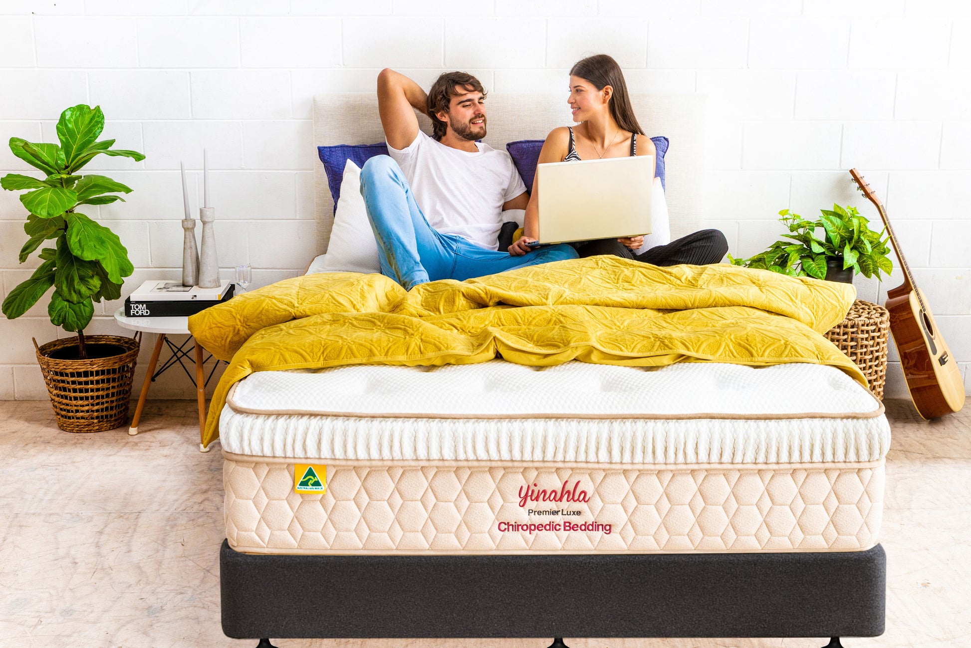 Couple relaxing on Yinahla Premier Luxe Chiropedic Bedding mattress with yellow quilt in modern bedroom